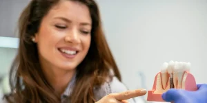 Interdental brushes and a soft toothbrush suffice for most people. A water flosser helps when spaces are tight.